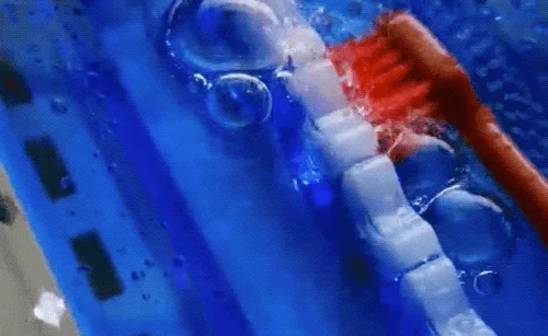 Demonstration of a moving toothbrush head and liquid around a tooth model.